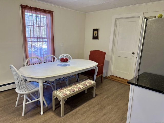 dining area with light wood-type flooring and crown molding