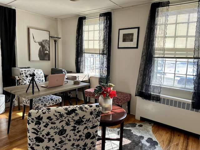 office space featuring radiator, crown molding, and wood finished floors