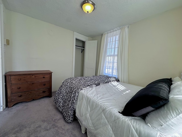 bedroom featuring a closet, light colored carpet, and a textured ceiling