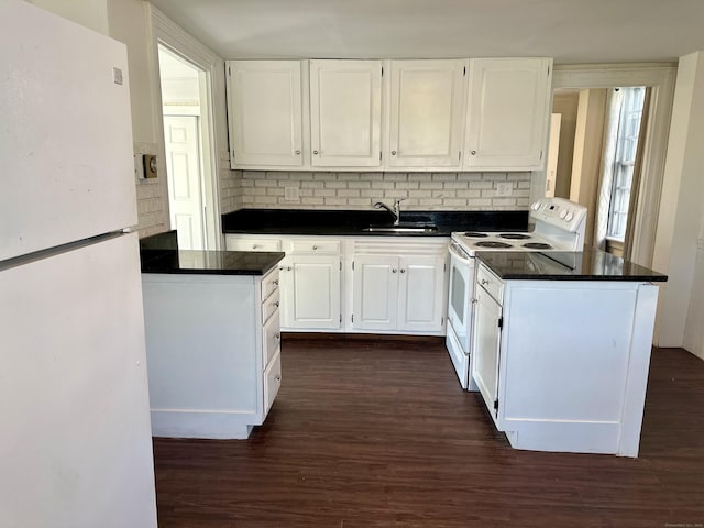 kitchen featuring dark countertops, white appliances, white cabinetry, and a sink