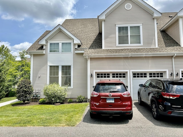 view of front facade with a shingled roof, a garage, a front lawn, and aphalt driveway