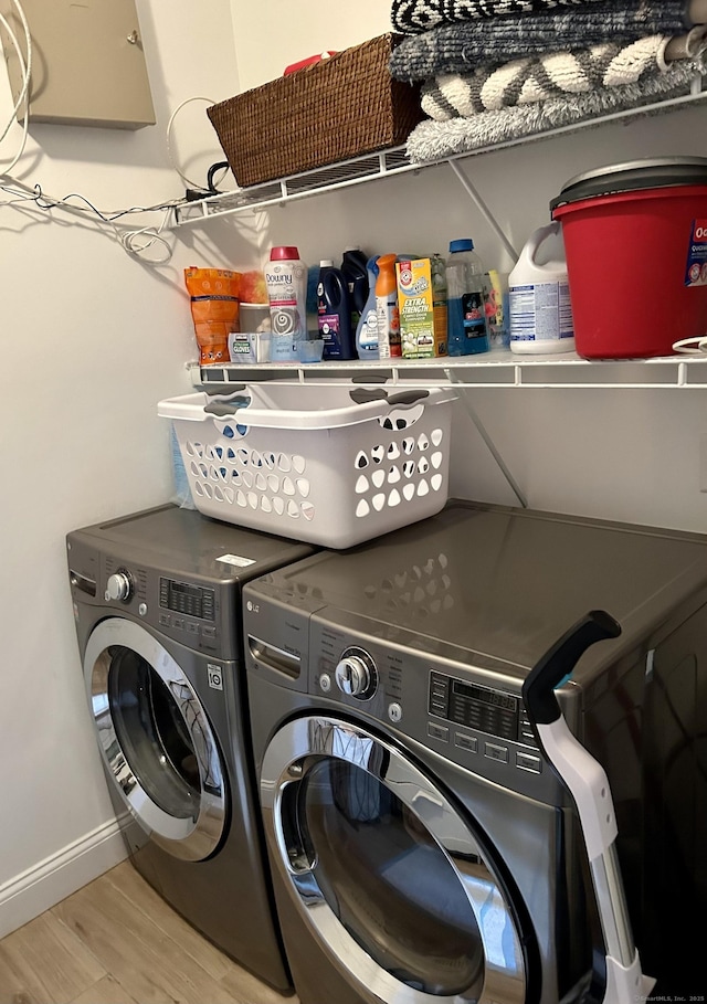 laundry room with laundry area, baseboards, separate washer and dryer, and light wood-style floors