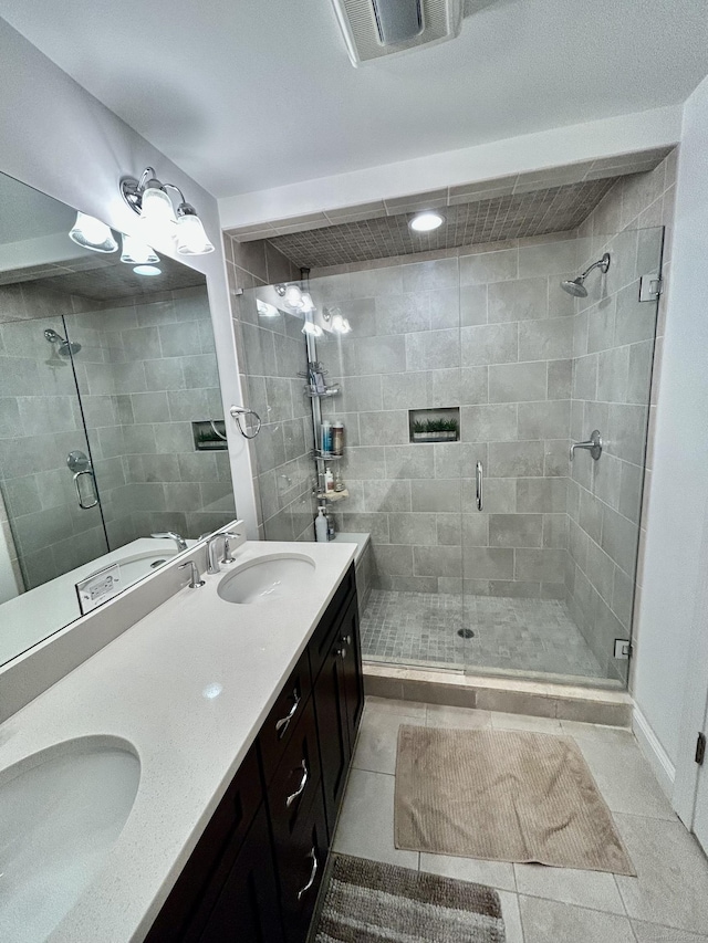 bathroom featuring visible vents, a sink, and tile patterned floors