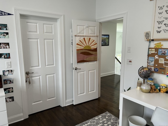 interior space with dark wood-style flooring and an upstairs landing