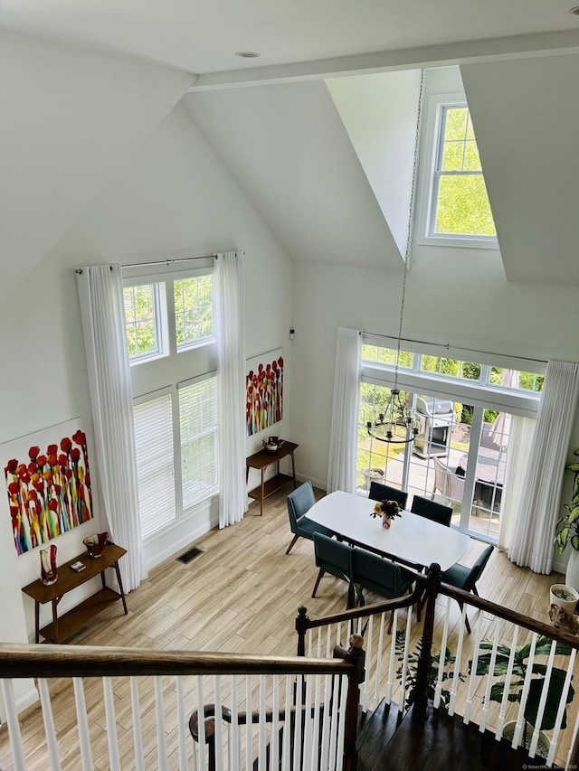 dining room featuring high vaulted ceiling, visible vents, a chandelier, and wood finished floors