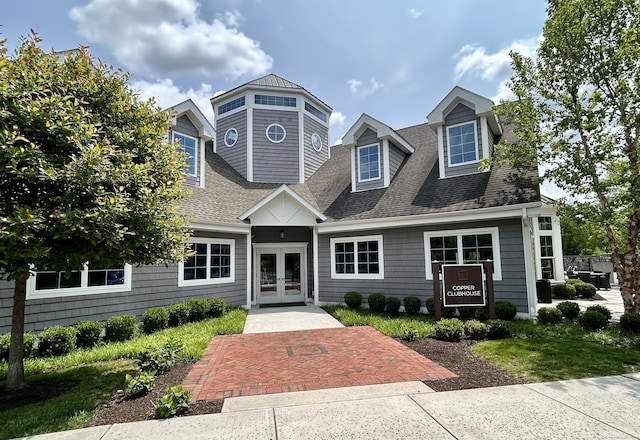 view of front facade featuring french doors and roof with shingles