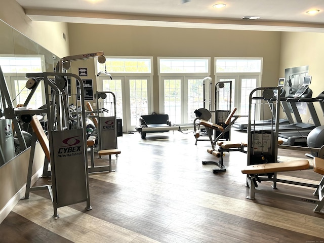 gym featuring wood finished floors, visible vents, and a healthy amount of sunlight