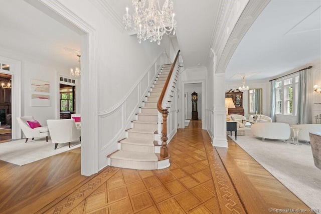 262 Brushy Ridge Rd, New Canaan, CT 06840 - entryway with a chandelier, ornamental molding, stairway, and a decorative wall