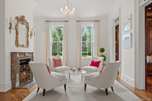 living area featuring ornamental molding, a premium fireplace, wood finished floors, and an inviting chandelier