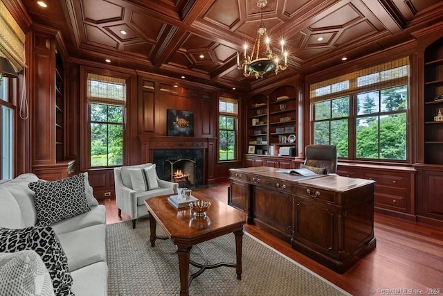 office area with wood walls, a high end fireplace, built in features, and ornamental molding