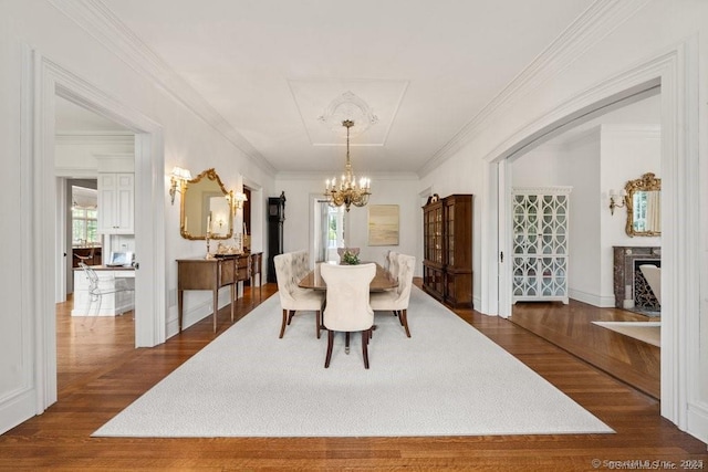 dining area with ornamental molding, dark wood-style flooring, and a notable chandelier