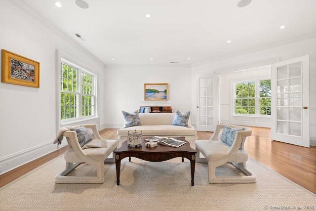 living area featuring light wood-style flooring, recessed lighting, visible vents, baseboards, and crown molding