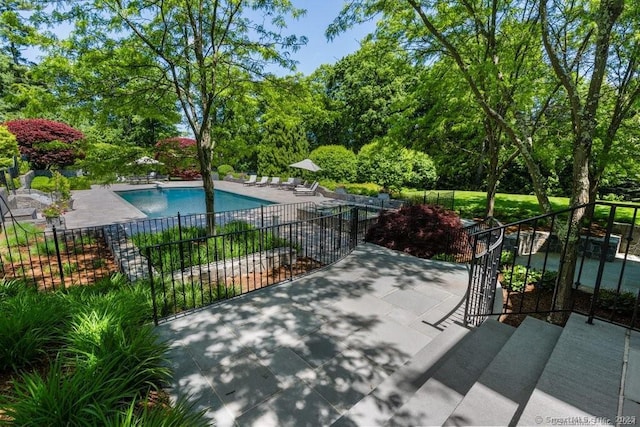 pool with a patio and fence