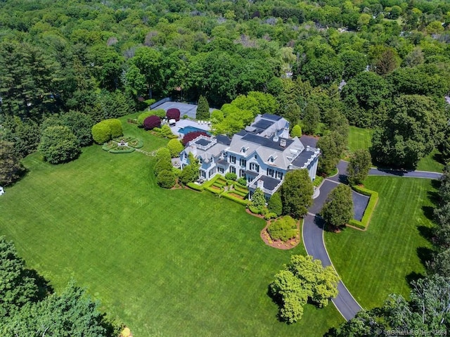 birds eye view of property featuring a forest view