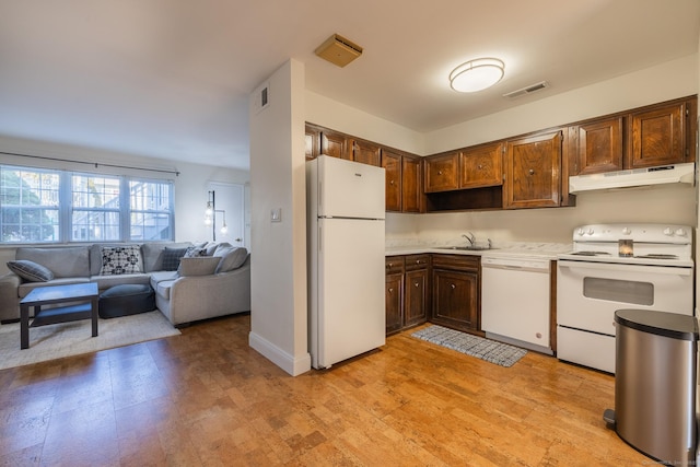 kitchen with under cabinet range hood, white appliances, a sink, visible vents, and light countertops