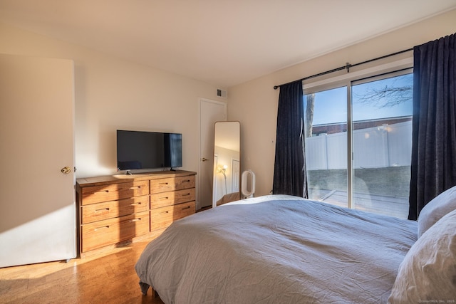 bedroom with access to exterior, visible vents, and light wood-style floors