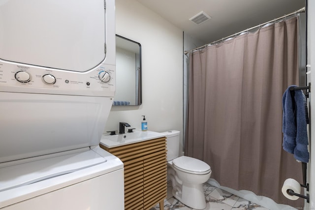 full bathroom with toilet, visible vents, vanity, marble finish floor, and stacked washer and clothes dryer