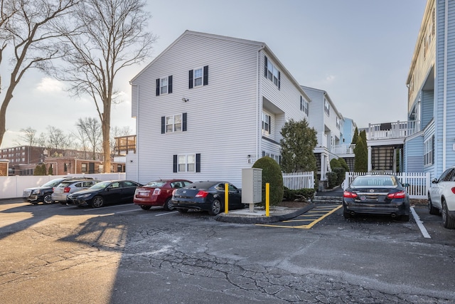 exterior space with uncovered parking, fence, and a residential view