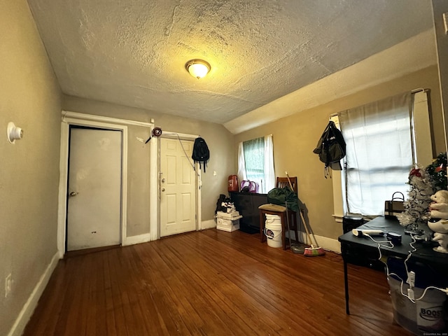 entrance foyer featuring wood-type flooring, baseboards, and a textured ceiling