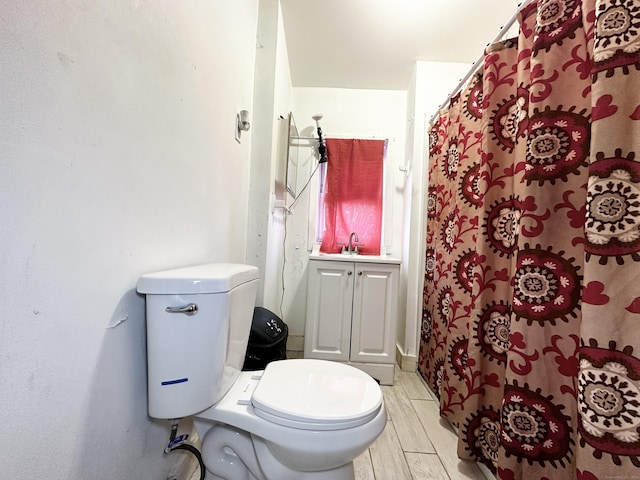 bathroom with wood tiled floor, a sink, and toilet