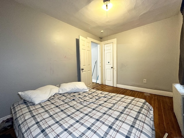 bedroom with dark wood-style floors and baseboards