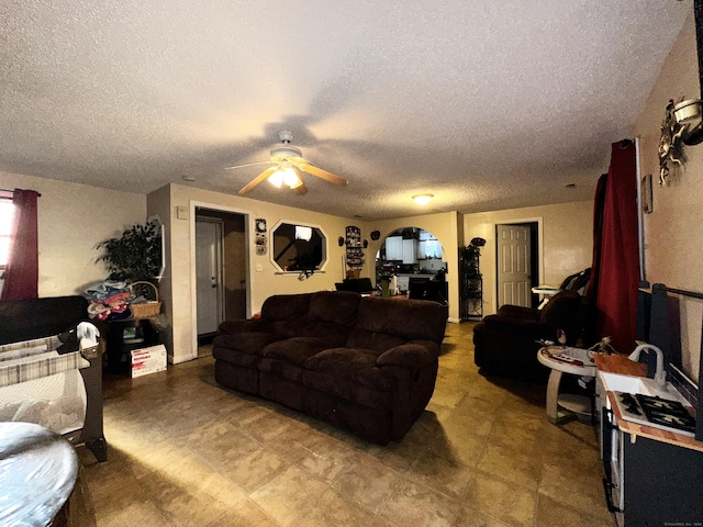 living area with a textured ceiling and a ceiling fan