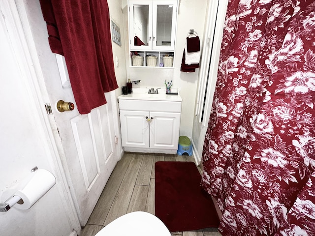 bathroom featuring vanity, toilet, and wood tiled floor