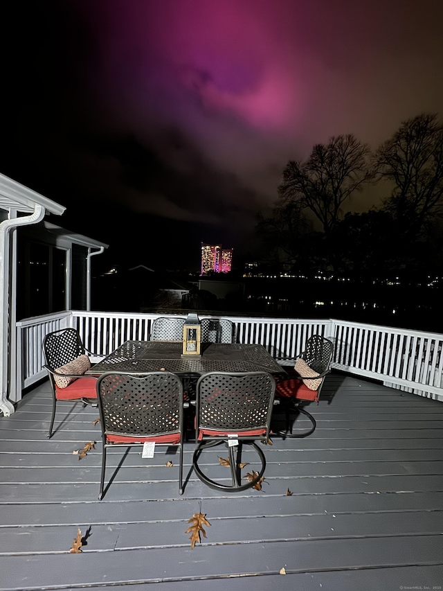 deck at twilight with outdoor dining space