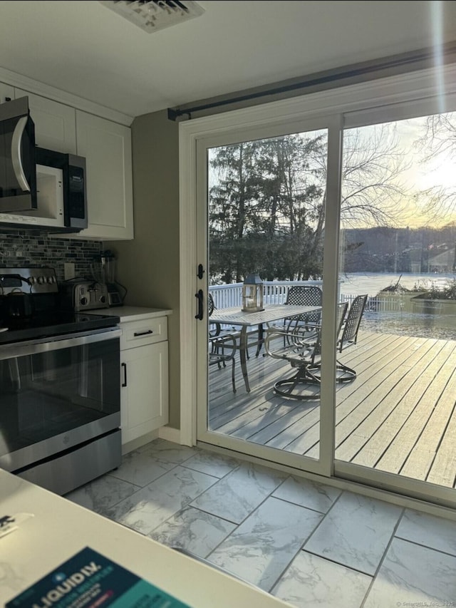 entryway featuring a water view, marble finish floor, and visible vents