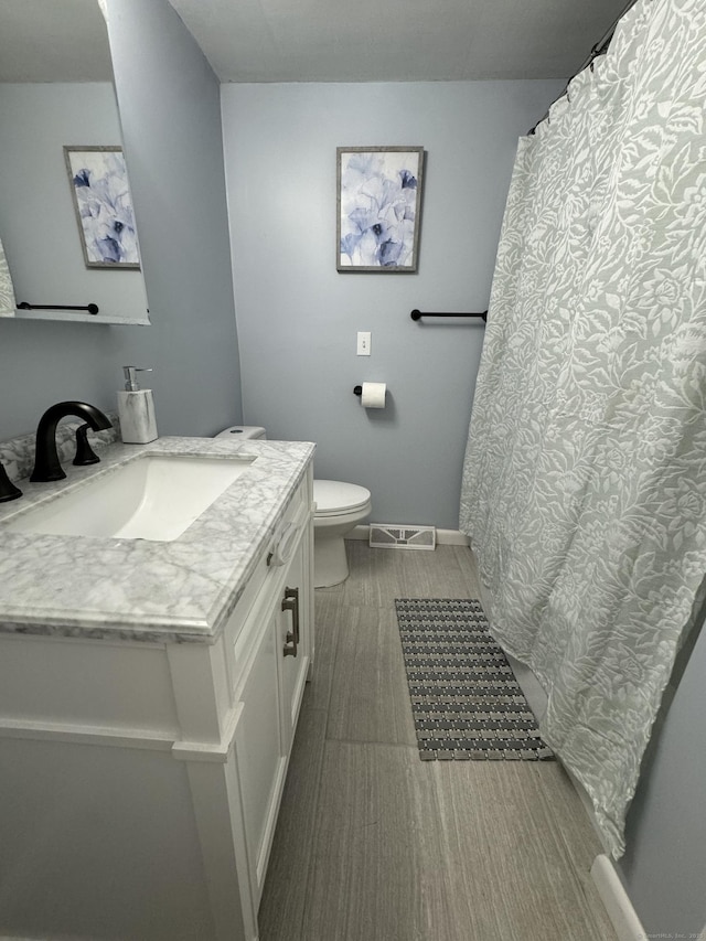 full bath featuring visible vents, vanity, and toilet