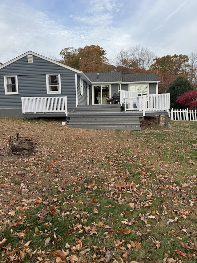 back of house featuring fence and a wooden deck