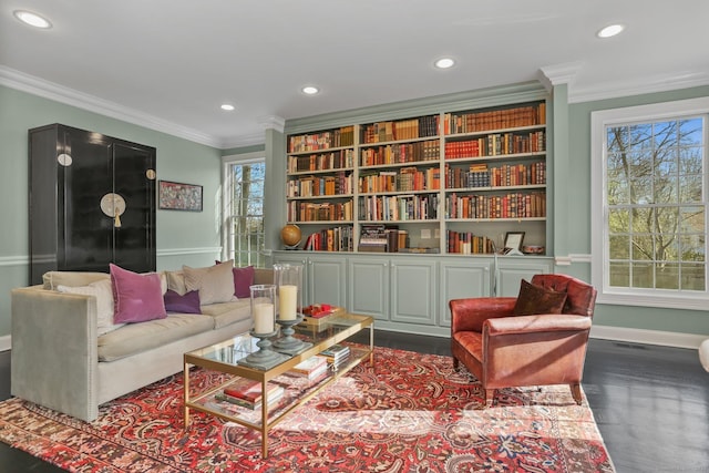 living area featuring plenty of natural light and crown molding