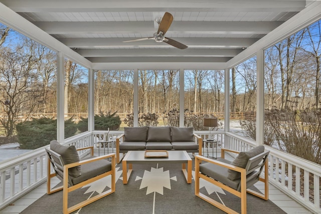 sunroom with ceiling fan and beam ceiling