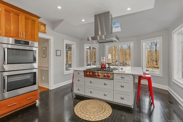 kitchen with stainless steel appliances, recessed lighting, light countertops, and island exhaust hood