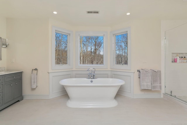 bathroom with a freestanding tub, recessed lighting, vanity, visible vents, and a stall shower