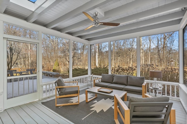 sunroom featuring a skylight, ceiling fan, and beam ceiling