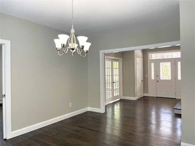 entrance foyer featuring dark wood-type flooring, baseboards, and an inviting chandelier