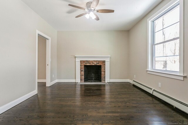 157R Sumner Wood Rd, Durham, CT 06422 - unfurnished living room featuring baseboard heating, baseboards, dark wood-style flooring, ceiling fan, and a brick fireplace