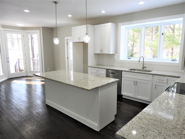 kitchen with dark wood finished floors, a sink, dishwasher, and light stone countertops