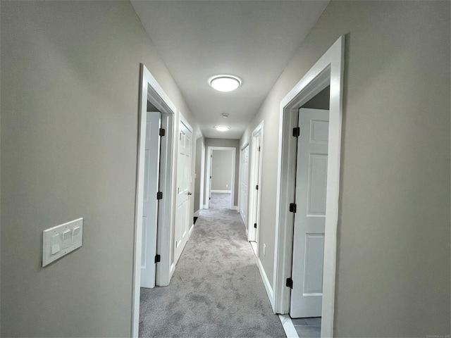 hall featuring carpet and baseboards