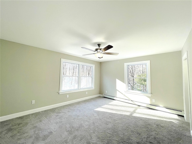 carpeted spare room featuring a baseboard heating unit, a ceiling fan, and baseboards