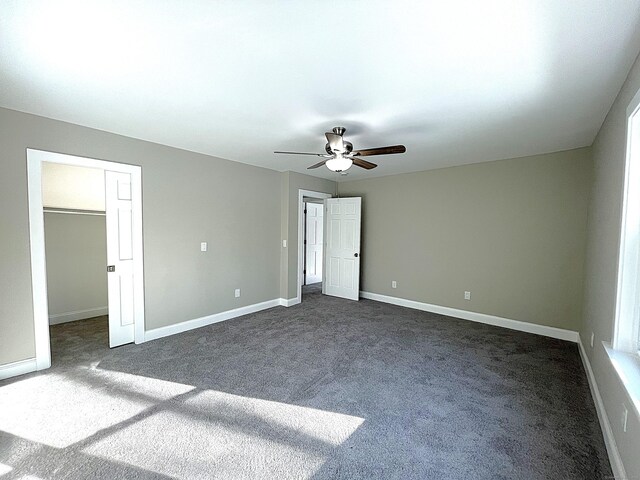 157R Sumner Wood Rd, Durham, CT 06422 - unfurnished bedroom featuring ceiling fan, baseboards, a walk in closet, and dark carpet