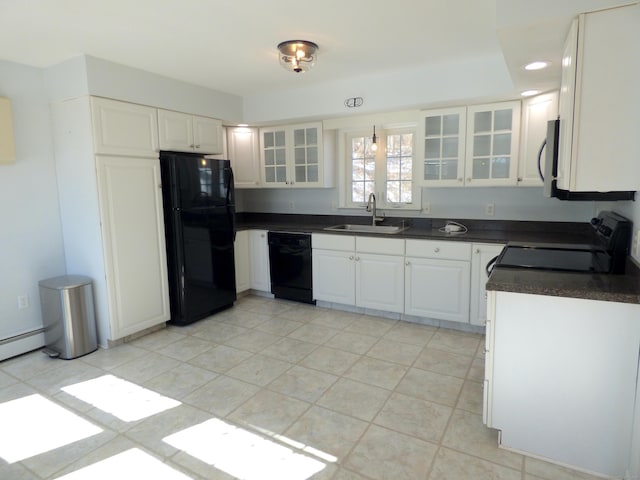 kitchen with dark countertops, glass insert cabinets, white cabinetry, a sink, and black appliances