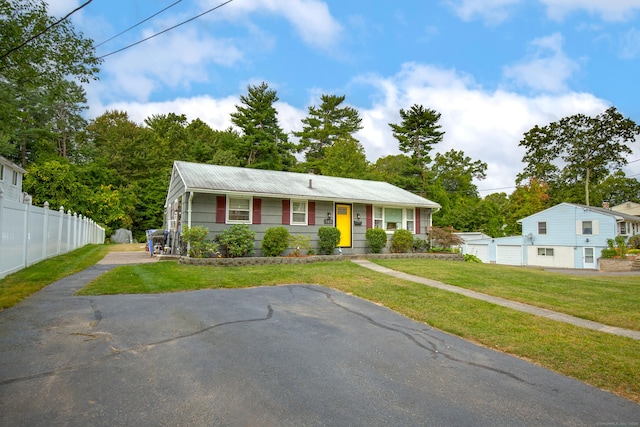 view of front facade featuring a garage, fence, aphalt driveway, and a front yard