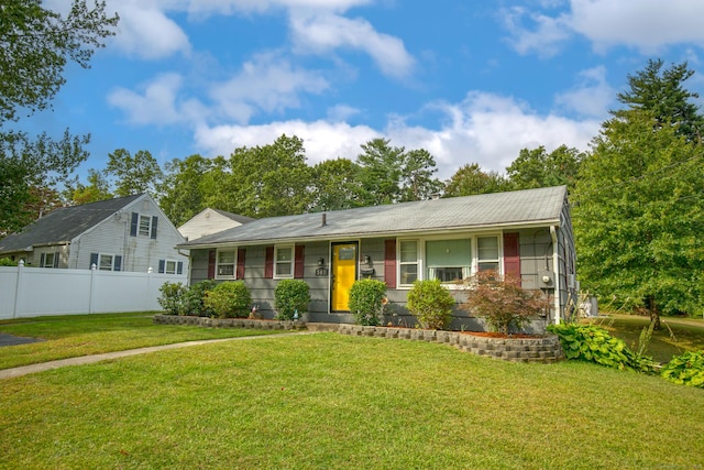 ranch-style home featuring fence and a front lawn