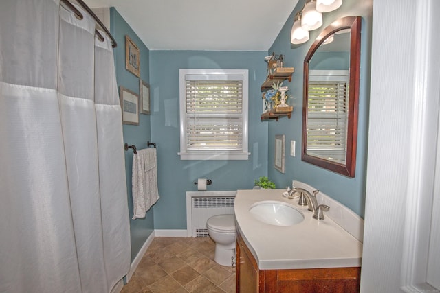 bathroom with toilet, a shower with shower curtain, vanity, baseboards, and radiator heating unit