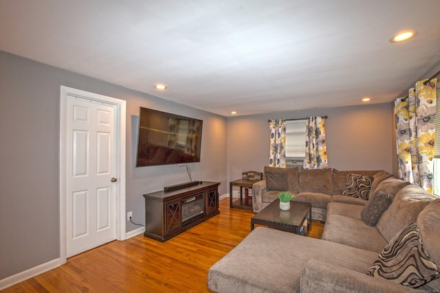 living room featuring recessed lighting, baseboards, and wood finished floors