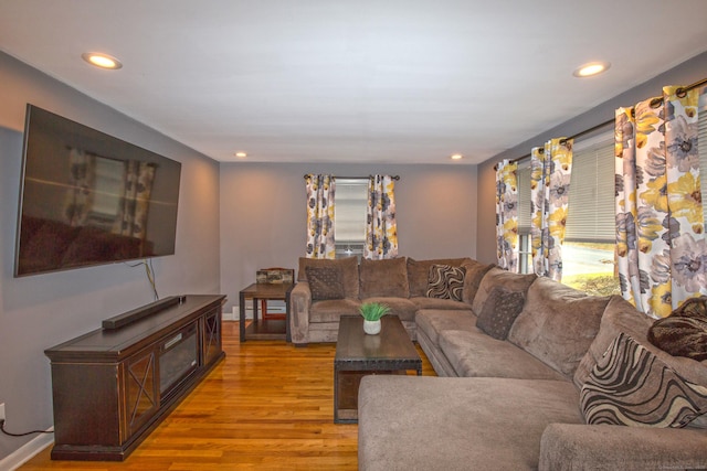 living room with light wood-style floors, recessed lighting, and baseboards