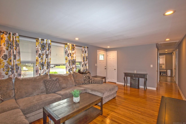 living area featuring attic access, baseboards, wood finished floors, and recessed lighting