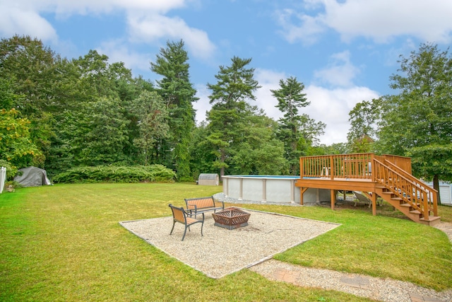 view of yard with an outdoor fire pit, an outdoor pool, stairway, and a wooden deck